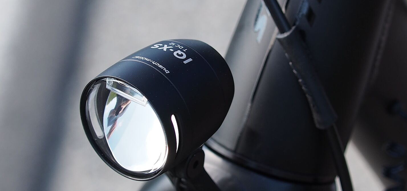 LED-Fahrradscheinwerfer Schwarzer LED-Fahrradscheinwerfer am silbernen Fahrradlenker montiert.